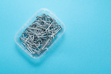 construction metal nails on blue background
