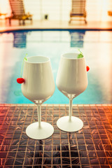 Two  Cocktails near the Swimming Pool on the Background. Exotic Summer Vacation