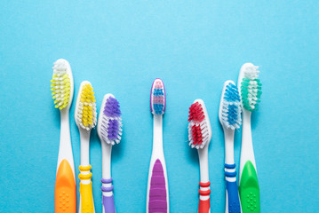 plastic colored toothbrushes on blue background