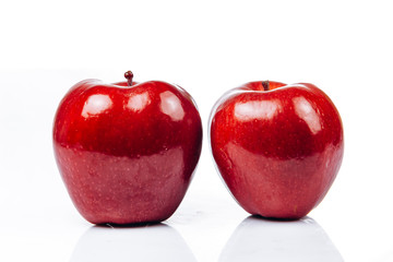 A few fresh red apples on a white background with a beautiful reflection