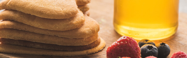 delicious heart shaped pancakes with berries on wooden board with honey, panoramic shot