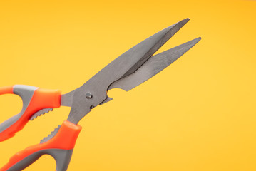 large kitchen metal scissors on yellow background