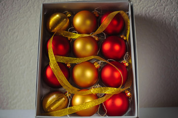 Red and gold christmas ball in white box. New Year and Christmas background