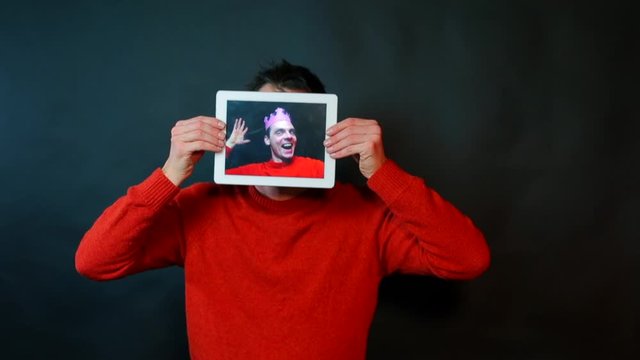 A man holds a tablet instead of a face.