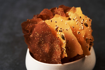 Cereal Chips with Seeds and kimchi mayonnaise sauce on dark background