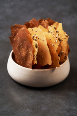 Cereal Chips with Seeds and kimchi mayonnaise sauce on dark background