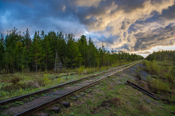 Old railway against the backdrop of a sunset in the evening after a thunderstorm.