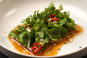 Smashed cucumbers plate with red chili pepper garlic parsley and vegetable oil