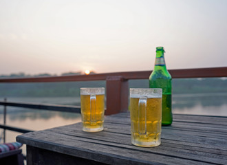 Bottle and two glasses of beer on the wooden table 