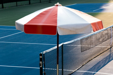 close up parasol and net in tennis court . © Rattanachai