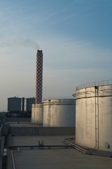 Storage Tanks And Smokestack Of Oil Industry