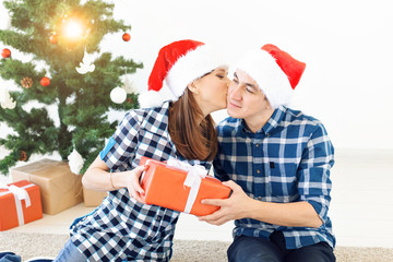 Holidays, christmas and family concept - Happy couple opening gifts at home.