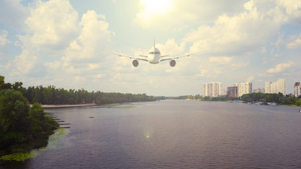 Airliner over the river in the city. The sun shines.