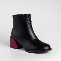 Graceful black womens leather demi season ankle boots in low fat red heels. Studio photo for catalog