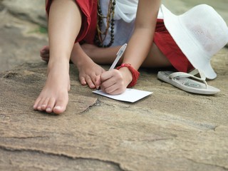 Lowsection Of Woman Writing On Paper Outdoors