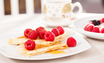 breakfast of pancakes with fresh raspberries on table
