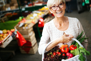 Only the best fruits and vegetables. Beautiful mature woman buying fresh food on market