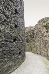 Detail of Inside a motte and bailey Castle in Cornwall.  Crumbling stone walls with a pathway