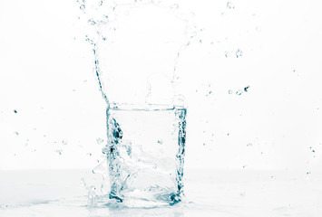 Naklejka na ściany i meble Refreshing liquid splashing into a glass 