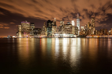 Fototapeta na wymiar New York night lights, Manhattan from Brooklyn side with reflections on water