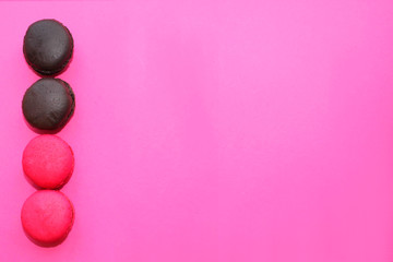 colorful raspberry, strawberry and chocolate macaroons on pink background, French biscuits.