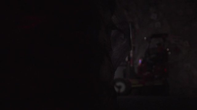 Slow motion footage of forklift unloading explosive in underground mine with wipe transition