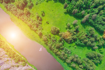 Top view of the river, green forest, several boats on the river.