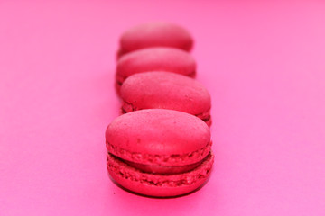 colorful raspberry, strawberry macaroons on pink background, French heart biscuits.