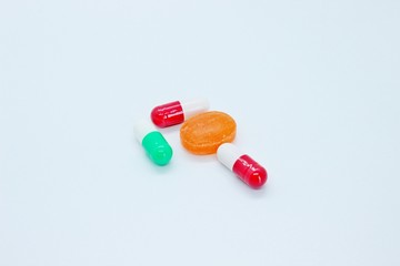 Multi-colored pills are located on a white background
