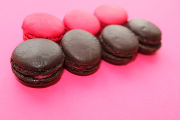 colorful raspberry, strawberry and chocolate macaroons on pink background, French biscuits.