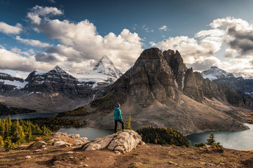 Women traveler standing on cliff with Mount Assiniboine on Niblet in provincial park