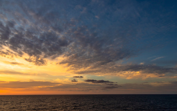 Sunset and dramatic set of clouds drifting over the tropical waters of the Caribbean Sea are lit by the last moments of daylight © Paulo