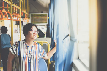 Asian woman travel by passenger bus in city