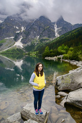 Naklejka premium woman relaxing on the lake and mountains sunny landscape
