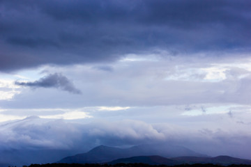 View of heavy rain falling on the Snowdonia Mountain range from the Isle of Anglesey