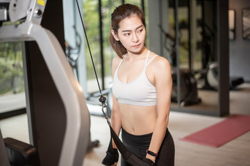 Fototapeta na wymiar Beautiful asian woman is doing exercise in the gym