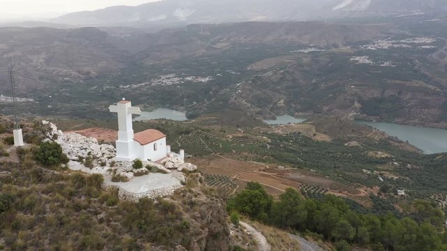 Cute tiny white church on hilltop in Pinos del Valle, Spain. Drone parallax right and down