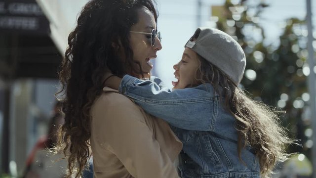 Close up of playful mother kissing and rubbing noses with daughter / San Francisco, California, United States