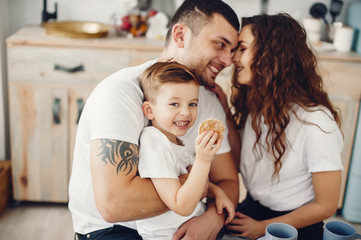 Family in a kitchen. Beautiful mother in a white t-shirt. Cute little boy