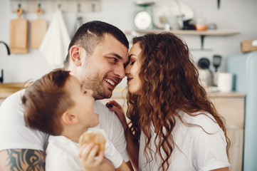 Family in a kitchen. Beautiful mother in a white t-shirt. Cute little boy