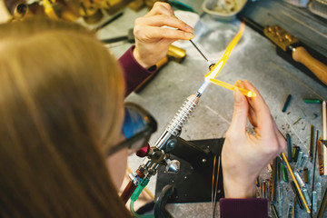 Artist in workshop making glass bead