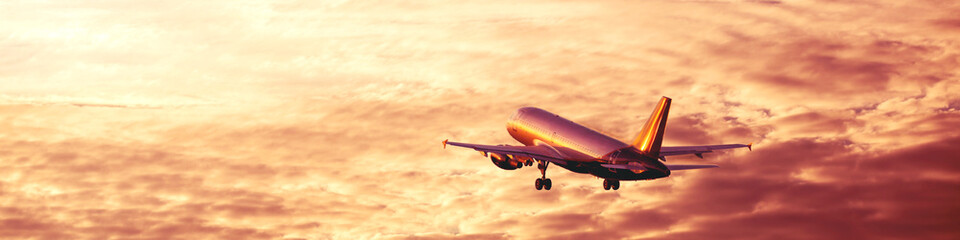 Airplane taking off and rising high in pink sunset sky, vacation concept