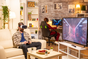 Man gamer using a VR headset to play video games in the living room