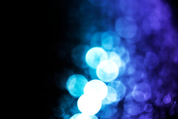 Abstract blue bokeh with black background defocused.