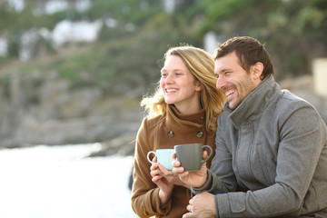 Happy couple of adults dating in winter on the beach