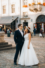 Bride and groom near the church in the city center early in the morning
