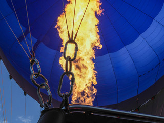 Obraz premium Hot air balloon flying in cloudy sky. Gas burner and flame.