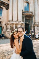 Bride and groom near the church in the city center early in the morning