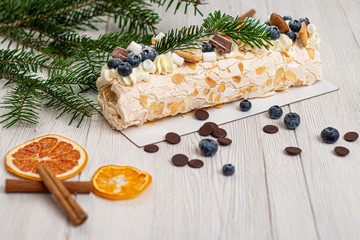 Christmas meringue roll with lemon, blueberry and chocolate