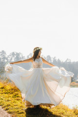 Fototapeta na wymiar The bride in a wreath whirls lifting her dress